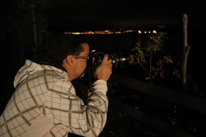 Laurent Silvani prend une photo sur le bord de La Baie durant la nuit. 