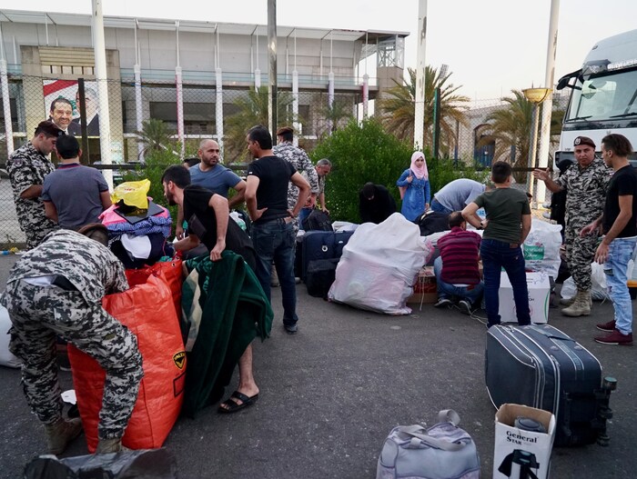 Des soldats libanais fouillent des sacs des réfugiés syriens.