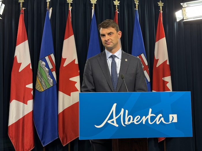 Le ministre Dan Williams en conférence de presse à Edmonton. 