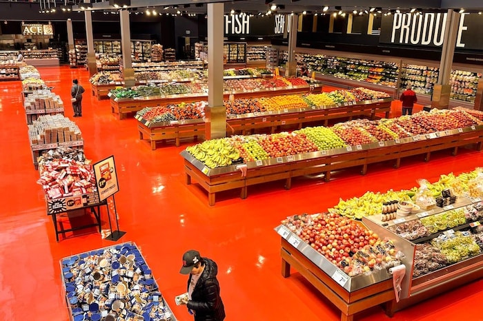 An aerial view of the produce section of a Loblaws grocery store with a few clients shopping.