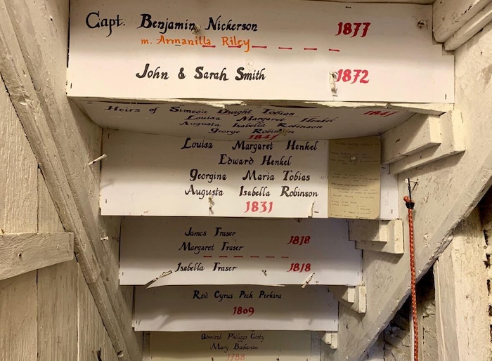 Noms et dates inscrits sur des cartons à l'endos des marches de l'escalier.