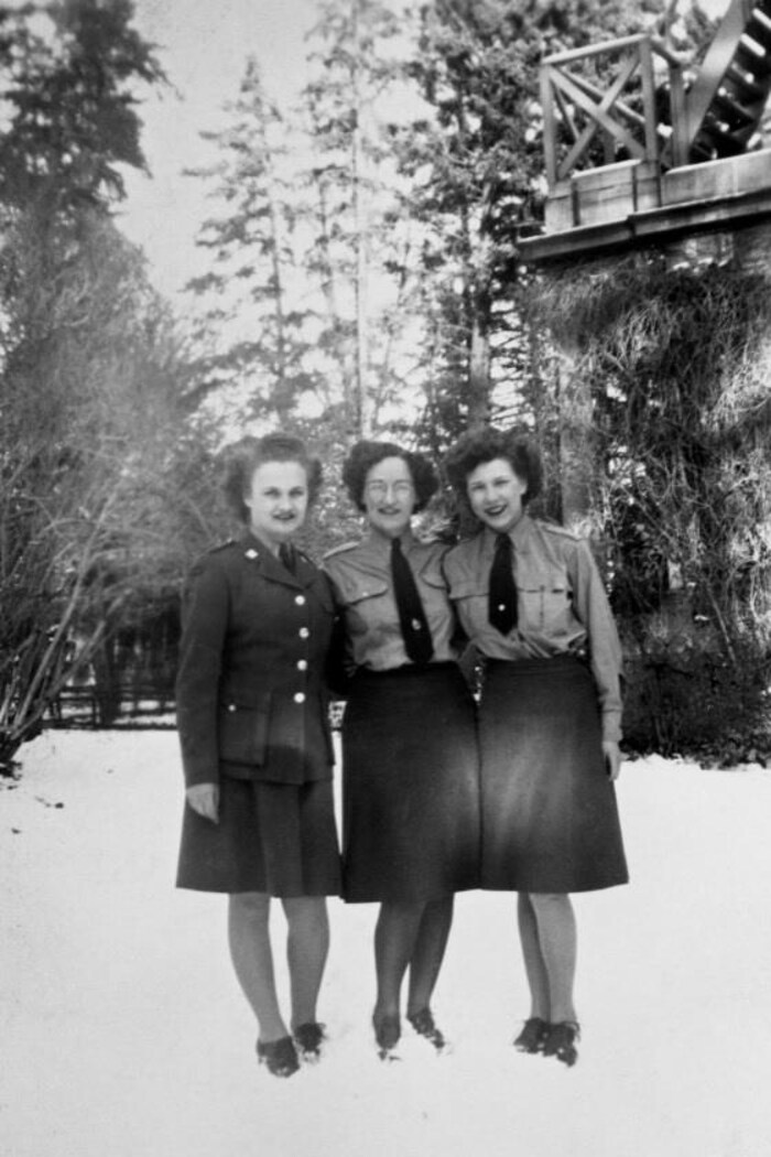 Une photographie d'époque en noir et blanc montre trois femmes membres du Service féminin de l'Armée canadienne posant debout dans la neige. 