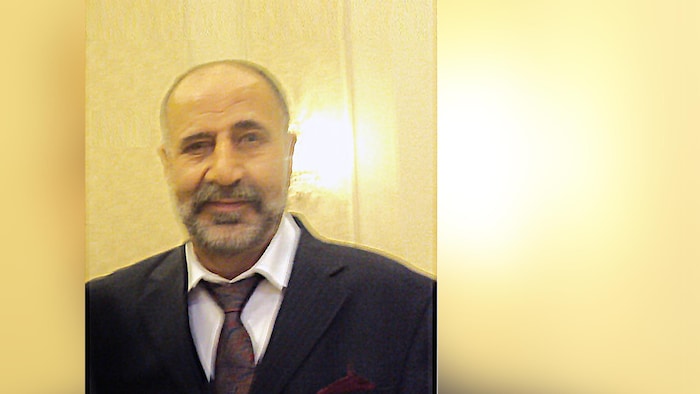 Portrait de Majeed Kayhan habillé en costume et cravate.