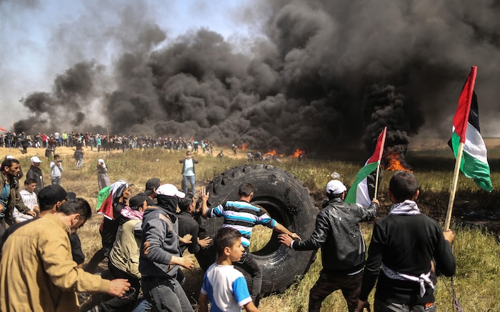 Des manifestants palestiniens brûlent des pneus.