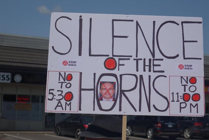 Une affiche sur laquelle on voit le visage de Steven Del Duca barré d'une croix rouge et écrit au-dessus : Silence, et demandant de faire taire les klaxons des trains.