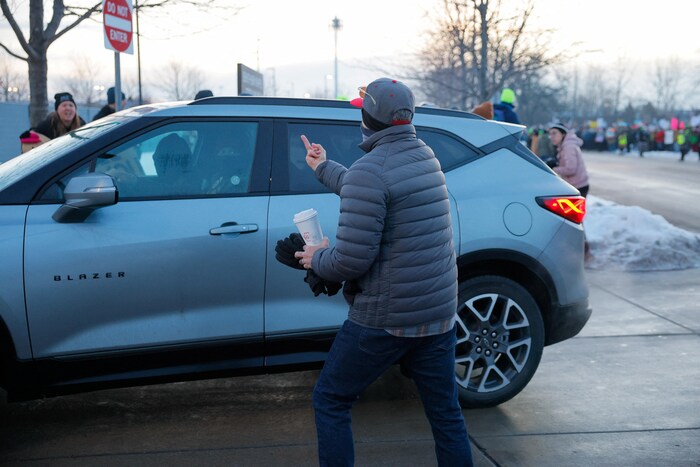 Un manifestant fait un doigt d'honneur à l'intention des agents de l'ICE masqués dans une voiture, devant des bureaux fédéraux de Minneapolis, le 8 janvier 2026.