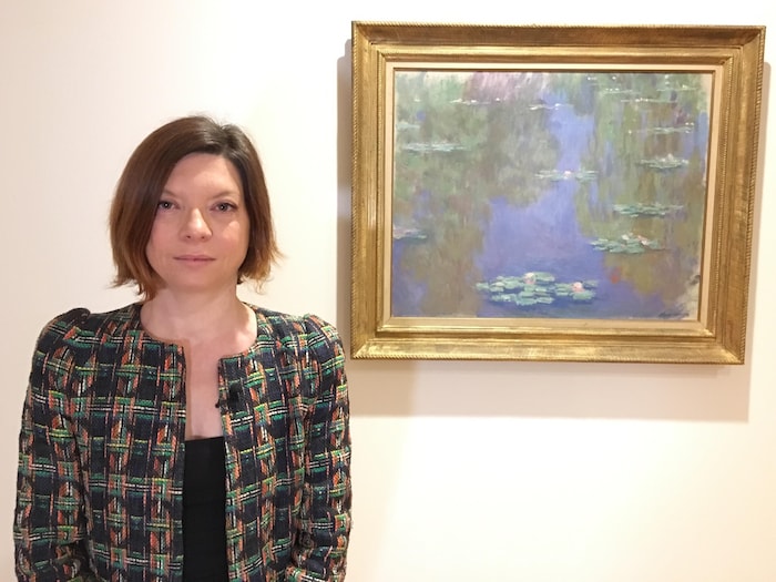 Marianne Mathieu, commissaire de l'exposition et directrice des collections du Musée Marmottan Monet pose à côté d'une toile de Claude Monet