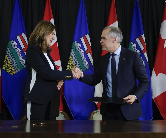 Mark Carney et Danielle Smith se serrent la main.