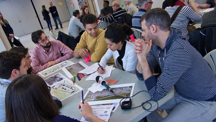 Une demi-douzaine de citoyens travaillent autour d'une table.