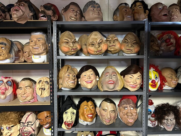 Des étagères industrielles en métal de plusieurs tablettes de haut avec des dizaines de masques en latex.