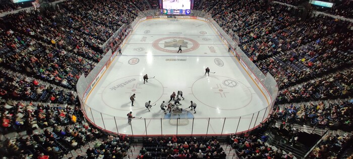 Photo de la patinoire prise du haut des gradins, pendant un match de hockey.