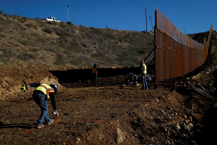 Des travailleurs de la construction travaillent sur une portion du mur entre San Diego et Tijuana le 13 décembre 2018.