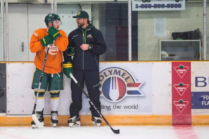 Nathan Oystrick discute avec le jeune sportif lors d'un entraînement à l'aréna Elgar Peterson.