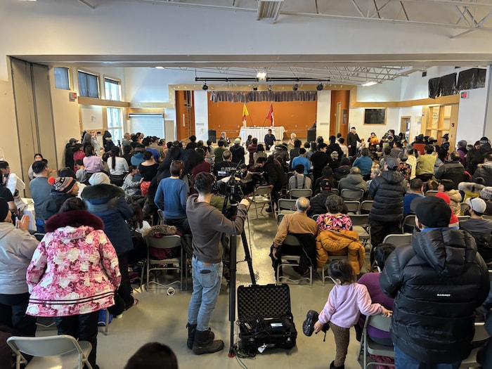Des dizaines de résidents d'Arctic Bay assistent à un discours du ministre des Relations Couronne-Autochtones et des Affaires du Nord dans la salle communautaire, le 27 février 2025.