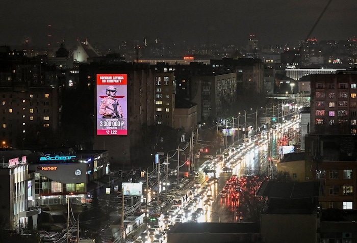 Une photo prise en hauteur d'un secteur urbain de la ville d'Omsk, le soir, montre une dense circulation automobile entre deux rangées d'immeubles de sept ou huit étages.