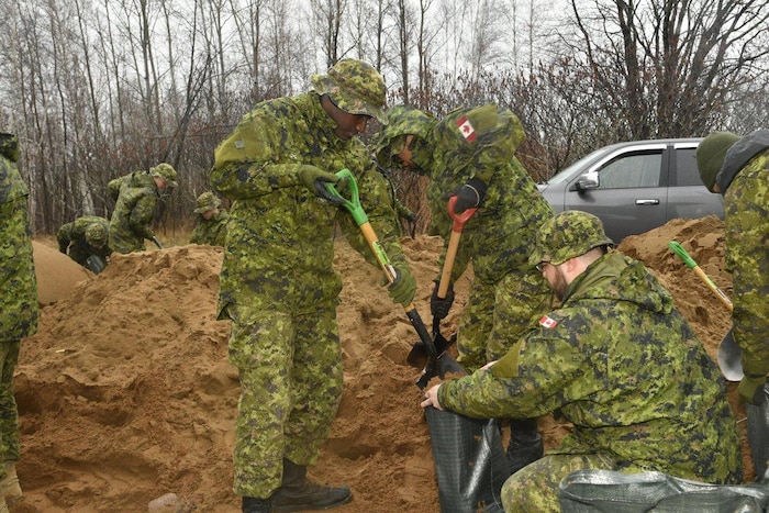 Un groupe de soldats remplit des sacs avec du sable