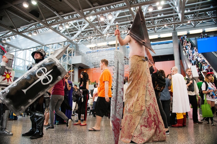Un homme en torse et affublé d'un énorme masque déambule au Palais des Congrès.