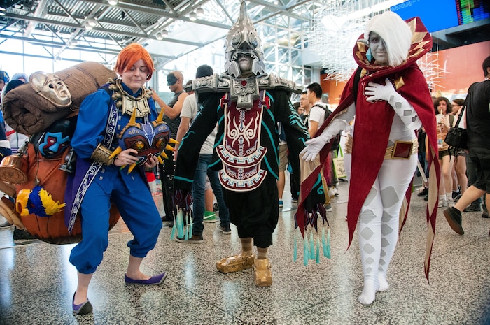 Trois personnes prennent la pose au Palais des Congrès, dans leur costume inspiré du jeu vidéo Zelda.