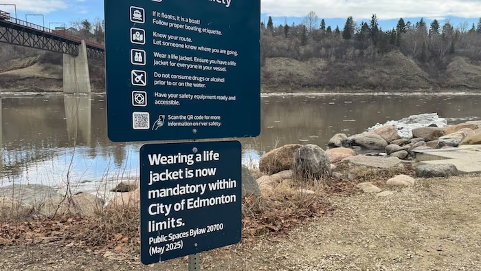 Un panneau indiquant en anglais qu'il est désormais obligatoire de porter un gilet de sauvetage pour naviguer sur la rivière Saskatchewan Nord, à Edmonton.