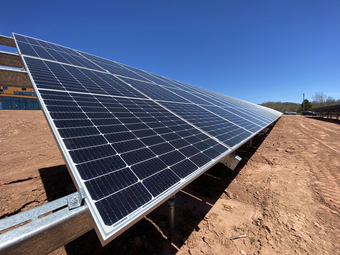 Panneau solaire installé au-dessus d'un sol de terre battue.