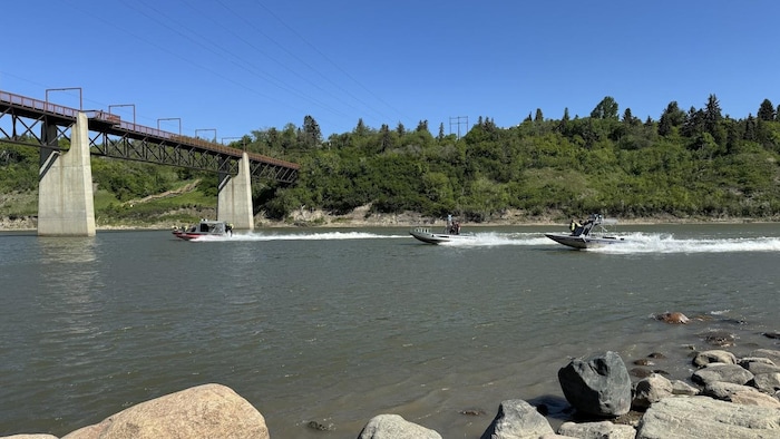 Trois bateaux naviguent sur la rivière Saskatchewan Nord à Edmonton.