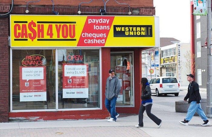 People walk past a payday loan store.