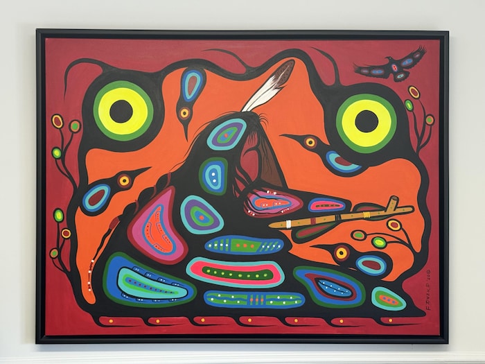 Une œuvre de style Woodland représentant une figure humaine entourée d’oiseaux et de formes colorées.