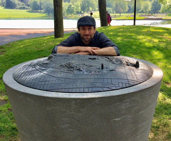 L'architecte Peter Soland, concepteur du volet « sur la montagne » du projet Escales découvertes. Il pose ici devant une carte tridimensionnelle installée près du pavillon du lac aux Castors.