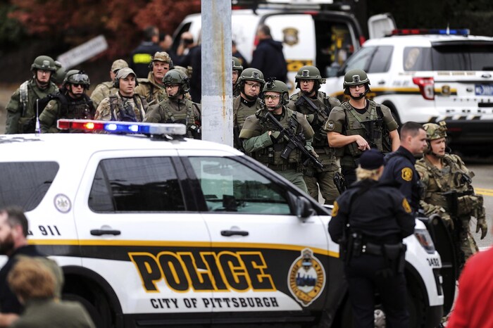 Une voiture de police de Pittsburgh à l'avant-plan; une douzaine de policiers lourdement équipés à l'arrière-plan.