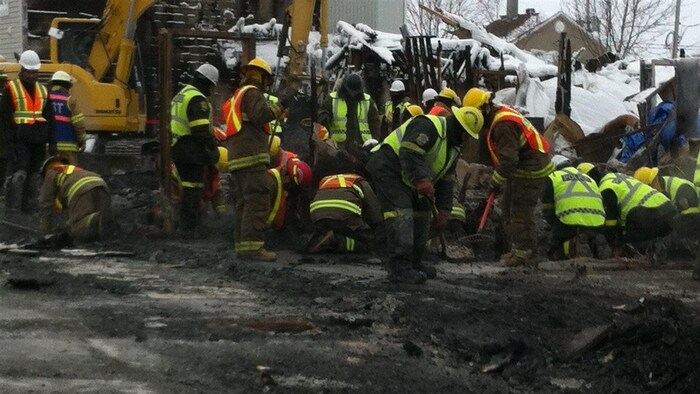 Des pompiers au travail sur le site de l'incendie.