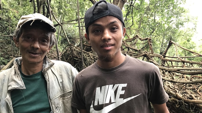 Hally et son fils Ronaldson travaillent sur un nouveau pont de racines dans le village de Siej. 