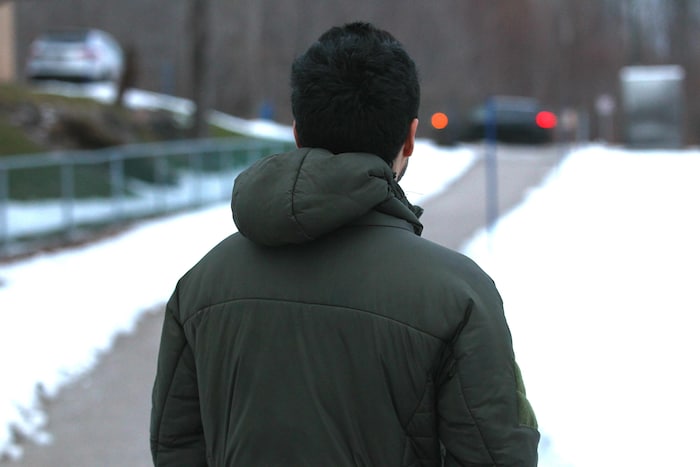 Un jeune homme photographié de façon anonyme pose de dos