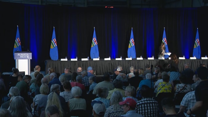 Des personnes sont rassemblées dans une salle pavoisée de drapeaux albertains, le 27 août 2025, à Lloydminster.