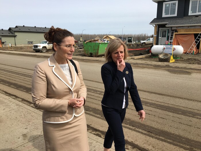 La première ministre de l'Alberta, Rachel Notley, et la mairesse de Fort McMurray, Melissa Blake, visitent un quartier en construction à Fort McMurray.