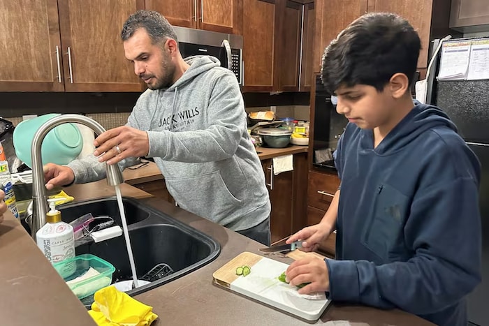 Un père et son garçon en cuisine.