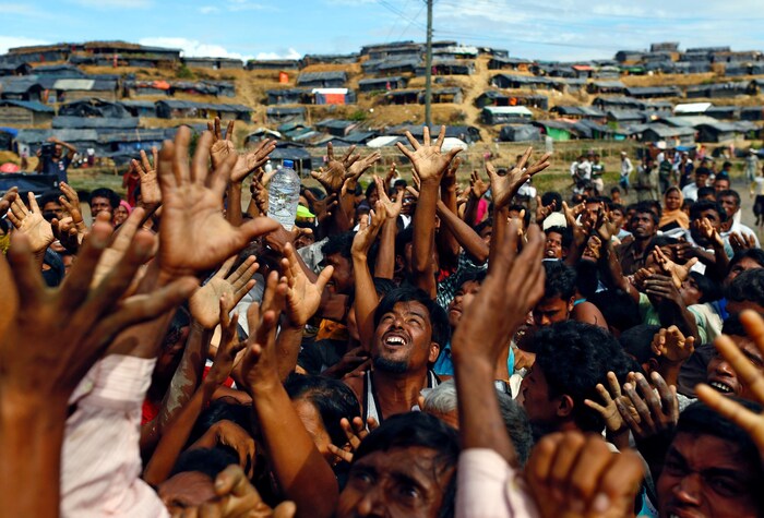 Des réfugiés rohingyas tentent d'agripper quelques vivres lors d'une distribution d'eau et de nourriture.