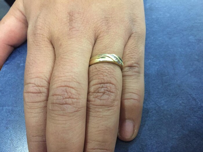 Une photo de l'anneau de mariage de Ricardo Miranda en or avec quatre diamants.