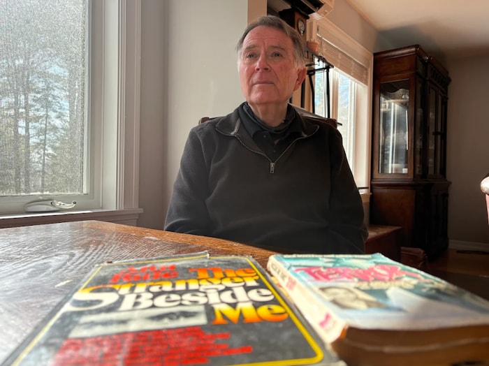 Rick MacLean pose avec des livres.
