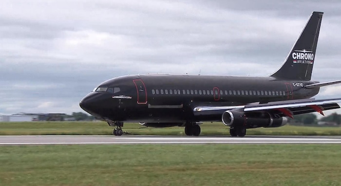 Un Boeing 737-200 de couleur noir roule sur la piste principale de l'aéroport de Saint-Hubert.