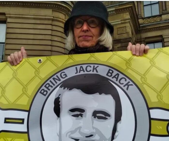 سالي لاين تحمل لافتة تطالب فيها بعودة ابنها جاك ليتس من معتقله في شمال شرق سوريا.