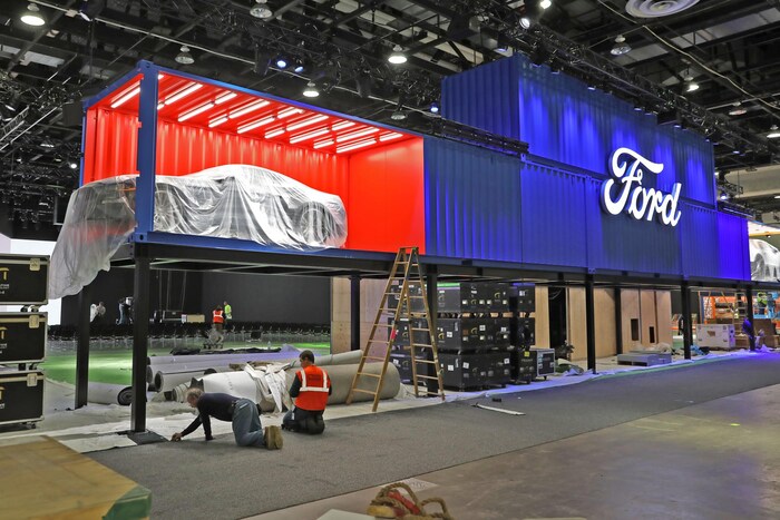 Des équipes s'affairent à préparer l'endroit où seront exposé les véhicules lors du Salon international de l'auto de Détroit