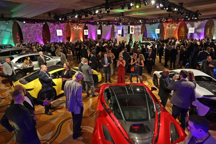 Des gens circulent parmi les voitures exposées au Salon international de l'auto de Détroit