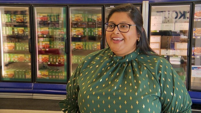 Sarah Khetty in the frozen aisle section of a grocery store.