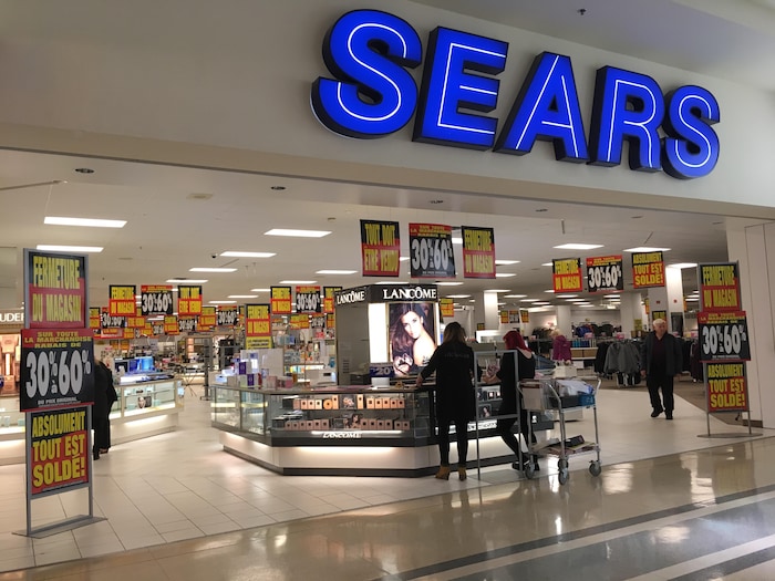 Des affiches annoncent des rabais de fermeture à l'entrée du magasin Sears.