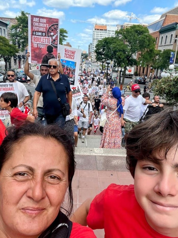 Sefika Ozlem Yaman Sahin et son fils pose au haut de marches alors que des manifestants les suivre.