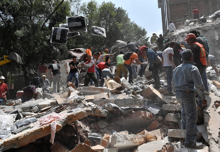 Des gens retirent des débris d'un bâtiment qui s'est effondré après le séisme de magnitude 7,1 survenu mardi, à la recherche de victimes éventuelles.