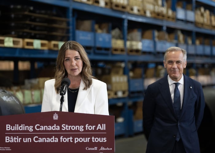 La première ministre de l’Alberta, Danielle Smith, se tient devant un pupitre tandis que, à sa gauche, se tient debout le premier ministre du Canada, Mark Carney, lors de l’annonce des détails concernant un nouveau pipeline, à Calgary, le 2 juillet 2026.