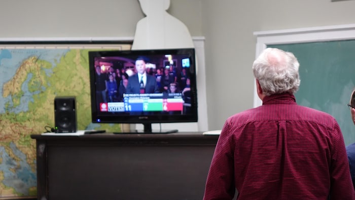 Le chef du Parti libéral écoute une entrevue à la télévision, lors de la soirée électorale. 