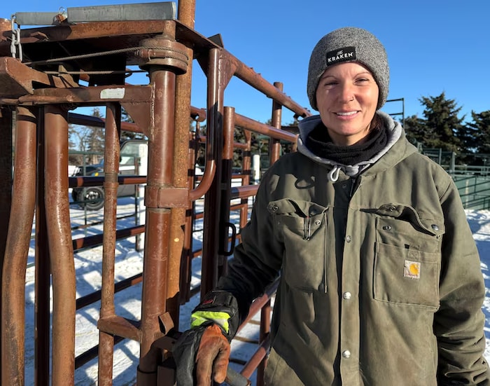 Une femme se tient debout dans une exploitation agricole en Alberta.