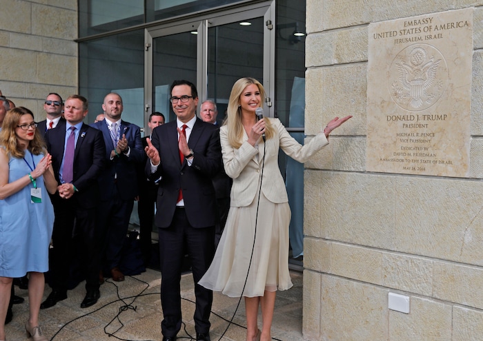 Le secrétaire au Trésor Steve Mnuchin applaudit aux côtés d'Ivanka Trump, qui montre la plaque sur laquelle on peut lire le nom de son père.
